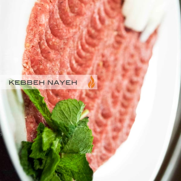 Byblos' Kebbeh Nayeh, a Mediterranean dish of raw minced meat, garnished with fresh mint leaves.