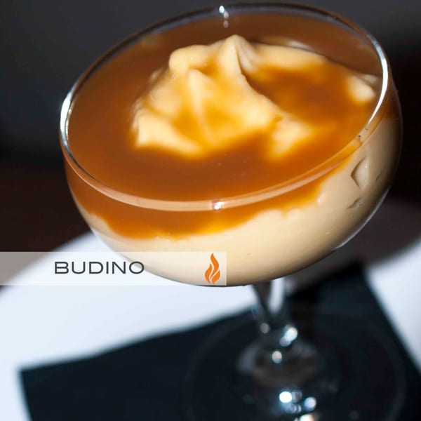 A glass of Byblos' Budino dessert, a creamy pudding topped with caramel sauce.